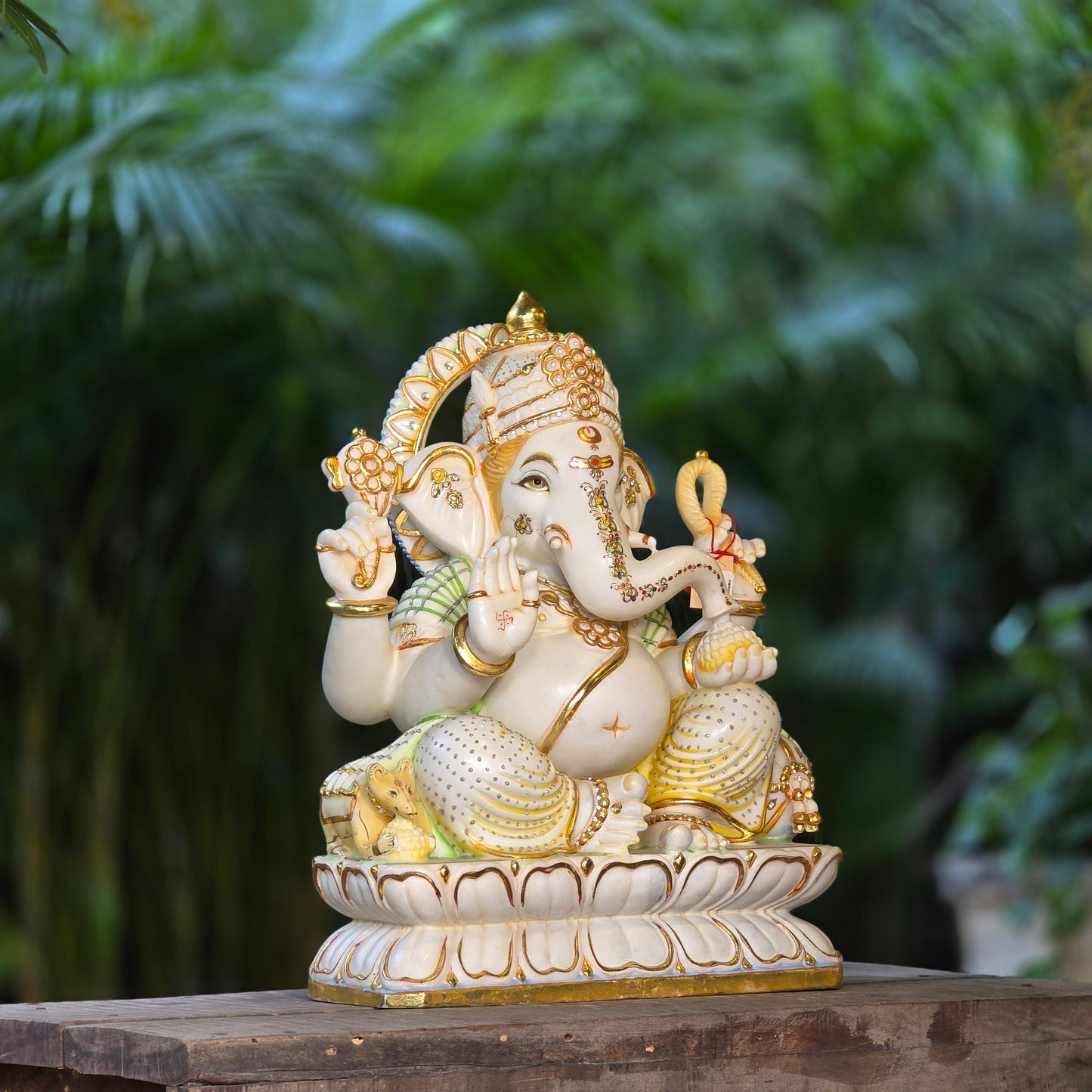 23" Chaturbuja Ganesha in Marble, this fine carving of Ganapati is sitting on a lotus base, its painted in light colours to add depth to the artifcat.