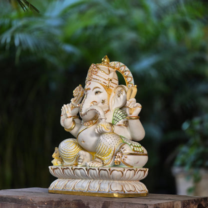 23" Chaturbuja Ganesha in Marble, this fine carving of Ganapati is sitting on a lotus base, its painted in light colours to add depth to the artifcat.